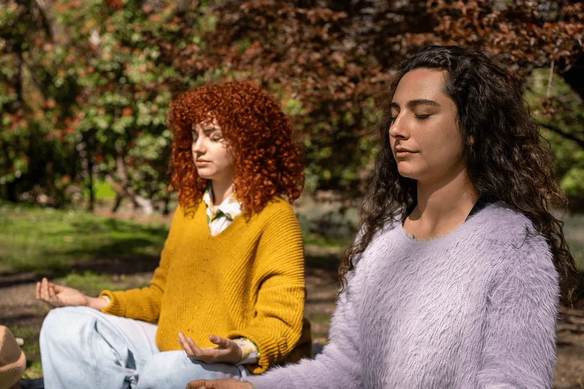Two students studying outdoors on a campus lawn