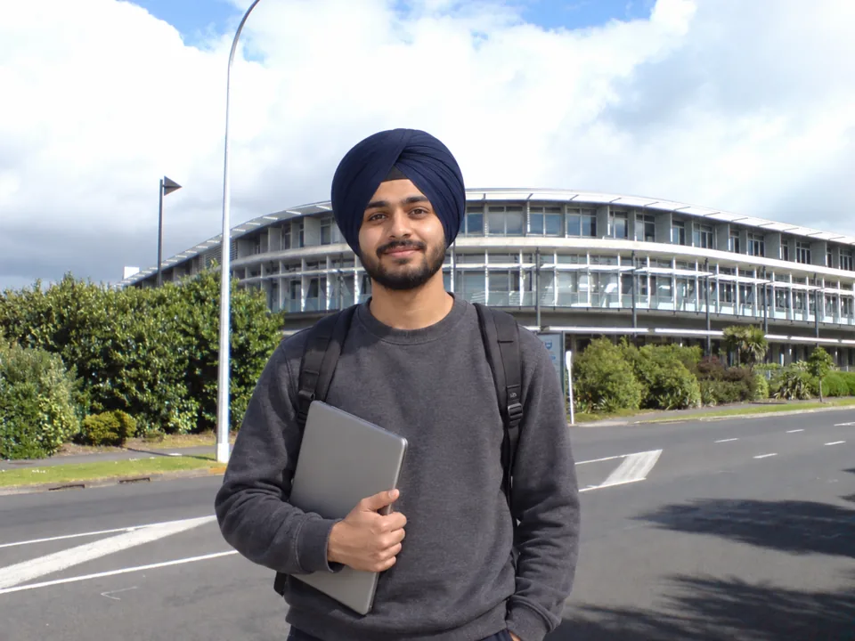 Indian computer science student in front of the University of Auckland campus